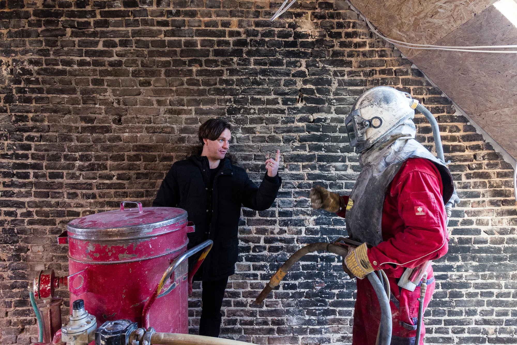 Matthias von Ohr auf der Baustelle beim Sandstrahlen der Ziegelwand